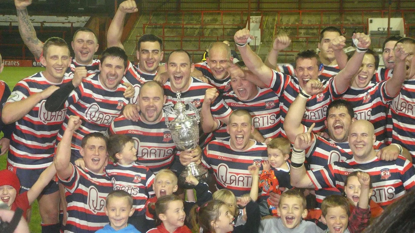 Players and children celebrating with the Valentine Cup trophy after the last final before the revival.